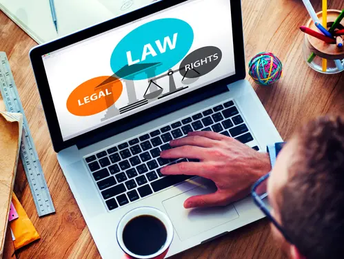 person using a laptop with the words "Law, Legal, Rights" on the screen